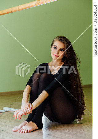Young beautiful girl ballet dancer sits on the 38624314