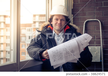 Construction engineer in hardhat with project in 38624571