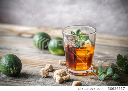 Glass of rum on the wooden background Glass of rum on the wooden background 38626637