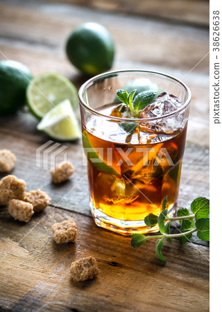 Glass of rum on the wooden background Glass of rum on the wooden background 38626638