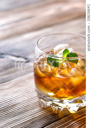 Glass of rum on the wooden background 38626641