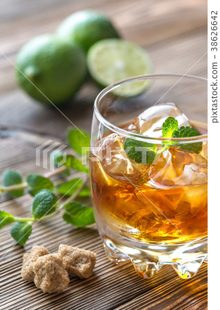 Glass of rum on the wooden background 38626642