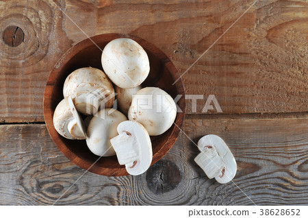 Fresh white mushrooms champignon in brown bowl Fresh white mushrooms champignon in brown bowl 38628652