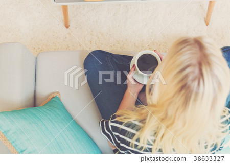 Happy young woman drinking coffee Happy young woman drinking coffee 38633327