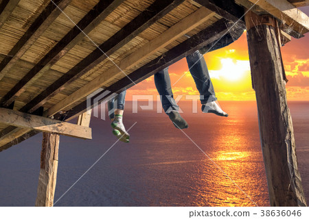 Tourists sitting legs hanging on wooden terrace 38636046