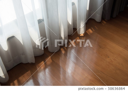 White curtains and brown wood floors 38636864