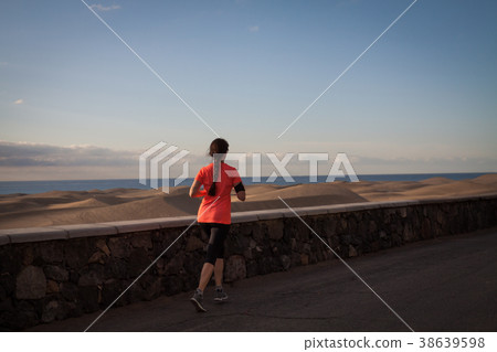 Running woman on seaside promenade  38639598