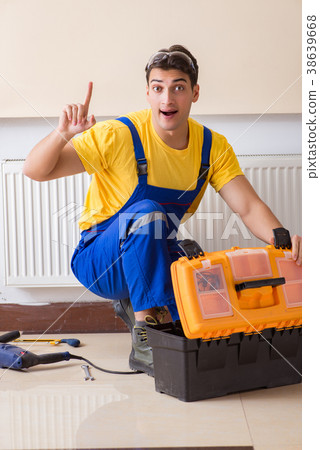 Young repairman contractor repairing heating panel Young repairman contractor repairing heating panel 38639668