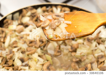 Mushrooms with onions are fried in a frying pan Mushrooms with onions are fried in a frying pan 38640106