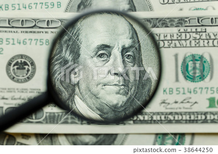 Magnifying glass on money background Magnifying glass on money background 38644250