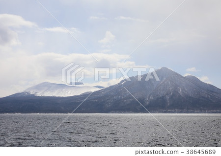 Windy immortals and Mount Tarumae seen from the shores of Lake Shikotsu in winter. 38645689