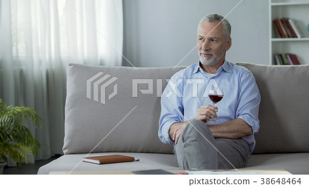 Happy adult person sitting on sofa, drinking red 38648464