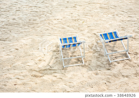 Chairs on sandy beach looking for the blue sea. 38648926