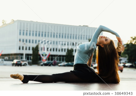 Ballerina sitting in gymnastic pose in middle of Ballerina sitting in gymnastic pose in middle of 38649343