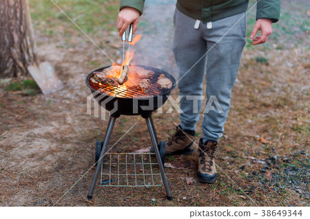Man cooking, only hands, he is grilling meat or 38649344