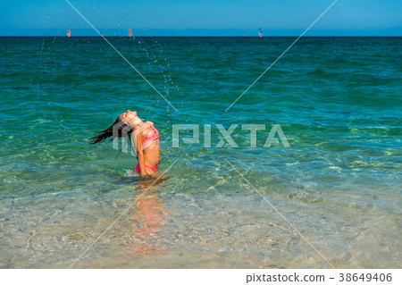 Girl having fun and splashing water Girl having fun and splashing water 38649406