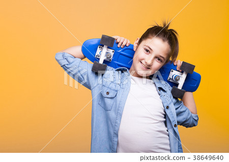 Teenager girl with a skateboard on her shoulders 38649640