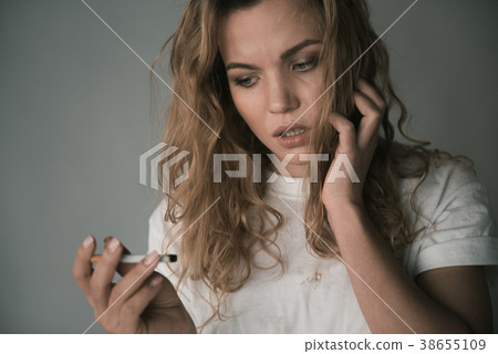 Irritated woman looking at coffin nail Irritated woman looking at coffin nail 38655109