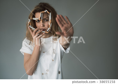Serious female smoker showing stop hand Serious female smoker showing stop hand 38655158