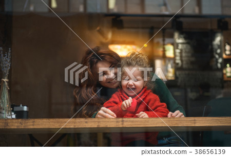 Excited girl sitting near her mom in cafeteria Excited girl sitting near her mom in cafeteria 38656139