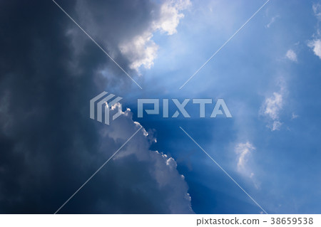 Clouds gathered in the sky under the sun. 38659538