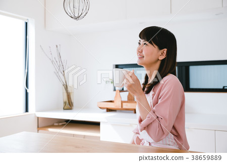 A woman drinking coffee in the kitchen 38659889
