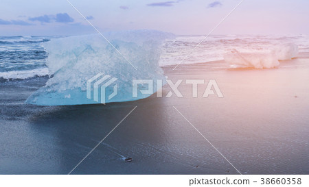 Glacier Ice breaking on black sand beach Glacier Ice breaking on black sand beach 38660358