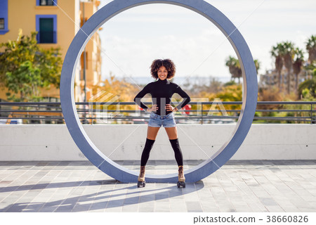 Black woman on roller skates riding outdoors on urban street Black woman on roller skates riding outdoors on urban street 38660826