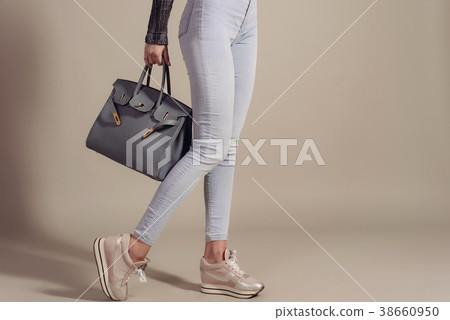 girl in jeans and sneakers holds fashionable bag girl in jeans and sneakers holds fashionable bag 38660950