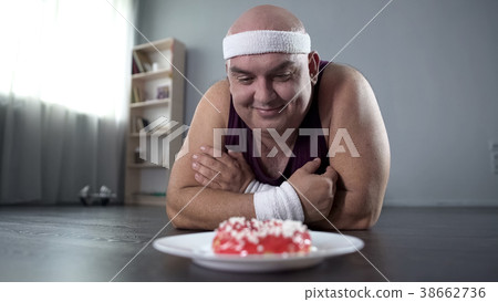 Funny corpulent man lying on the floor and looking Funny corpulent man lying on the floor and looking 38662736