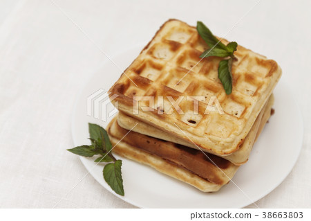 Belgian waffles with fresh mint on a white plate 38663803