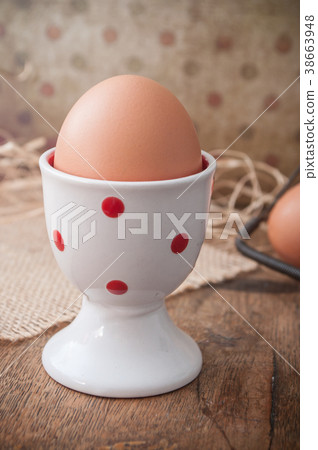 closeup of eggs with eggcup on wooden table 38663948