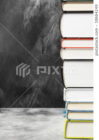 Pile of various books on dark background Pile of various books on dark background 38664249