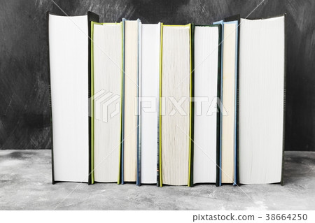 Pile of various books on dark background Pile of various books on dark background 38664250