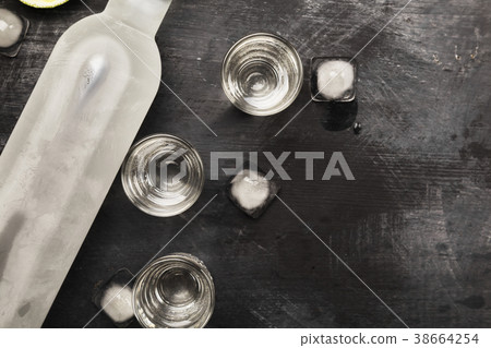 Cold vodka in shot glasses on a black background Cold vodka in shot glasses on a black background 38664254