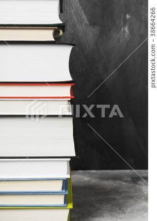 Pile of various books on dark background Pile of various books on dark background 38664266
