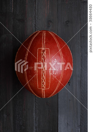 Vintage brown oval ball on the black wooden floor 38664480