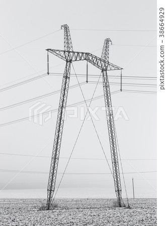 Hi-voltage electric power lines in a wintry foggy 38664929