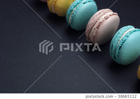Flat lay pastel macaroons on dark background 38665112