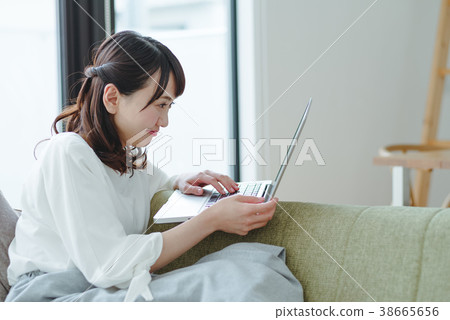 一個女人在客廳裡看電腦 38665656
