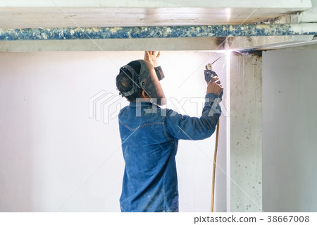 worker with mask welding metal structure 38667008