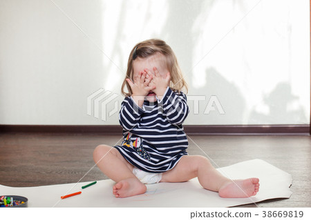 little girl is sitting on the floor, having fun 38669819