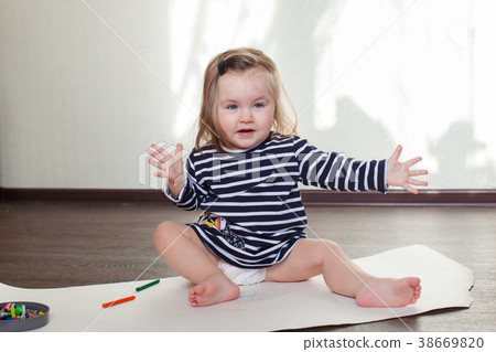 little girl is sitting on the floor, having fun 38669820