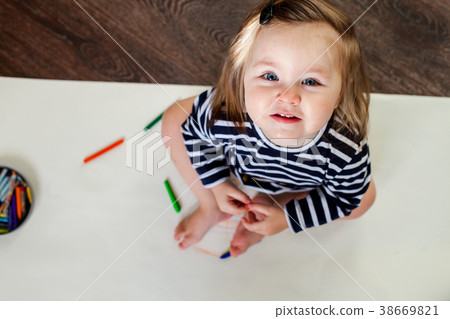 1 year old girl sitting on the floor with pencils 38669821
