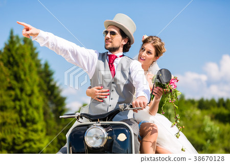 Bridal pair driving motor scooter wearing gown and Bridal pair driving motor scooter wearing gown and 38670128