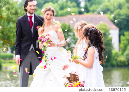 Wedding couple and bridesmaid showering flowers 38670135