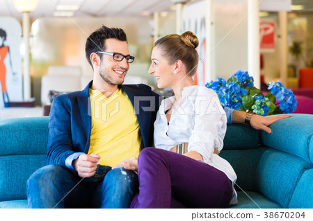 Couple buying couch in furniture store Couple buying couch in furniture store 38670204