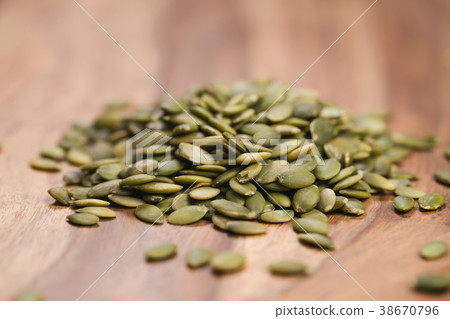green pumkin seeds on wooden table 38670796