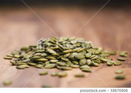 green pumkin seeds on wooden table 38670806