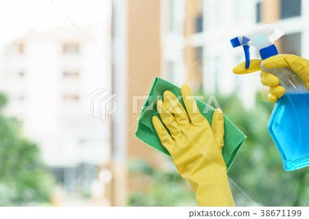 Woman housekeeper cleaning the mirror with cloth. Woman housekeeper cleaning the mirror with cloth. 38671199